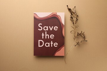 Wall Mural - Beautiful card with Save the Date phrase and dry branch on beige background, top view