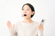© siro46 - スマートフォンを持って驚く女性　白背景