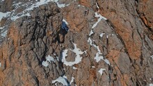 A Drone View Of A Herd Of Mountain Goats Running The Steep Slope.Wild Mountain Goats On Rugged Cliffs On A Snowy Day.They Climb The Steep Cliff.Mountain Goats Living In Mountainous.Great Natural View.