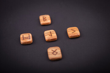 Sticker - runes for predictions burned on wooden plates on a black background