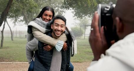 Poster - Couple, piggyback and photographer at park to take picture, bonding and smile on holiday in winter fog. Interracial, man and woman taking photo on vacation for happy memory, love and care in nature