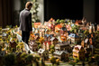 A thoughtful man gazes over a detailed miniature town, showcasing expert modeling in urban design and architecture.