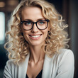 Young adult stylish confident attractive smiling blonde European business woman, beautiful lady pretty model with curly blond hair wearing glasses looking at camera, close up face portrait indoors.