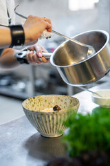 Poster - woman chef cooking seafood soup on restaurant kitchen