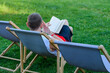 Czas wolny, mężczyzna relaksuje się na leżaku czyta książkę 