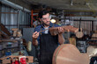 © surachetkhamsuk - Luthier is working on the neck of a classical guitar