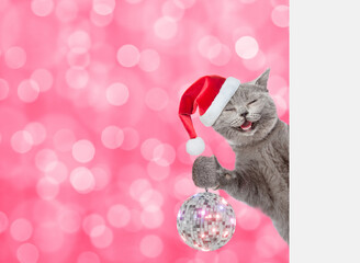 Aufkleber - Smiling cat wearing red christmas hat looks from behind empty white banner and shows disco ball. Festive background. Empty space for text