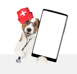 Aufkleber - Smart jack russell terrier wearing like a doctor with stethoscope on his neck showing big smartphone with white blank screen in it paw above empty white banner. isolated on white background
