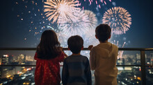 Back View Of Children Watching Big Fireworks In The Evening Sky While Standing On An Open Area