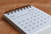 February 2024 White Table Calendar On Wooden Background. Calendar Concept.