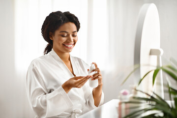 Poster - Skincare Routine. Attractive Black Female Applying Makeup Removal Milk On Cotton Pad