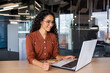 Young beautiful successful hispanic woman working inside office with laptop, businesswoman happy and satisfied holding bank credit card in hands, shopping in online store, choosing gifts