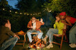 © Nomad_Soul - Teenager having fun at bonfire telling horror stories spending time at campsite
