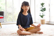 © aekkorn - Asian girl sits on floor practice yoga .happy girl child rest on floor meditate relieve negative emotions on weekend at home.