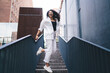 © BullRun - Excited woman jumping on stairs with raised arm