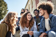 © Alexandr - Multinational students have fun chatting on the steps at the entrance to the university.