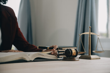 Justice and law concept.Male judge in a courtroom with the gavel, working with, computer and docking keyboard, eyeglasses, on table in morning light