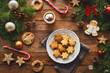Draufsicht eines rustikalen Holztisches mit weihnachtlicher Dekoration, Süssigkeiten, Weihnachtskeksen und Kakao