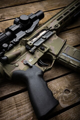 Poster - A modern carbine with an optical sight and a silencer. Weapons in camouflage coloring. Old wooden back