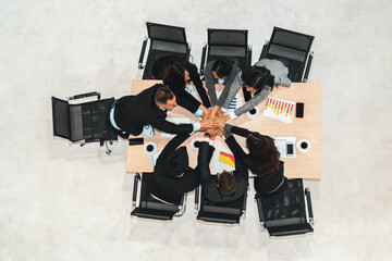 Wall Mural - Happy business people celebrate teamwork success together with joy at office table shot from top view . Young businessman and businesswoman workers express cheerful victory show unity support . Jivy