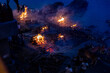 View of body cremation with firewood and fire on the banks of Ganges River at Manikarnika Ghat in Varanasi in India.