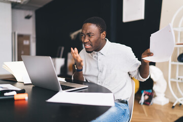 anxious african american man reading documents in office