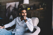 © BullRun - Thoughtful young man sitting on sofa in living room