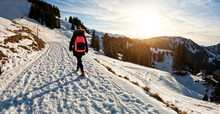 Young Woman Walking On Snow Mountain Track During Winter Time At Sunset - Travel And Landscape Nature Concept - Focus On Body