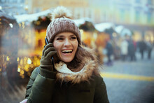 Smiling Woman At Christmas Fair In City Talking On Phone