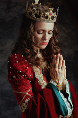 Wall Mural - medieval queen in red dress with rosary and crown praying