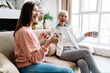 © BullRun - Cheerful multiethnic women laughing while sitting on couch