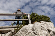 © Guzel - Bottom view of a man standing on a steep slope against the sky and looking into the distance, Austria