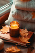 Lit Candle Casting a Warm Glow, Surrounded by the Rich Tapestry of Fall's Fading Leaves, Bountiful Harvest of Pumpkins, and Luscious Apples, Inviting You to Savor the Season's Cozy Charm 