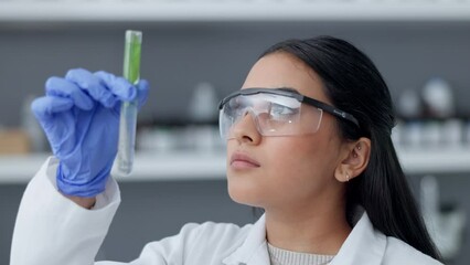 Poster - Medical research, serious female scientist analyzing liquid biochemical in test tube while working in a laboratory. Closeup up face of woman wearing gloves and goggles for safety while experimenting