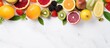 Top view of a variety of tropical summer fruits displayed on a white marble background The image showcases fresh unprocessed and nutritious vegan food There is empty space available for copy
