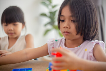 Wall Mural - Adorable little girl playing toy blocks in a bright room