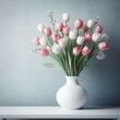 A white vase with a bouquet of pink and white tulips on a white shelf against a blue-grey background