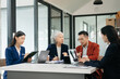 © laddawan - Group of young Asian business people discussing business plan at startup in office