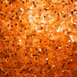 Orange sparkle glitter sequins background. Backdrop with glowing palliettes. Scattered аrom above closeup