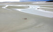 elevated panoramic view from Mont Saint Michel Abbey France and little people walking at low tide