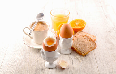 Wall Mural - Soft boiled egg with orange juice, bread and coffee cup
