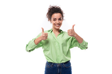 Wall Mural - young cute brunette businesswoman with curly hair tied in a ponytail in a light green shirt points with fingers