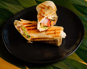 Sticker - Shawarma sandwich - fresh roll of thin lavash or pita bread filled with grilled meat, mushrooms, cheese, cabbage, carrots, sauce, green. Traditional Eastern snack.