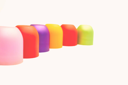 Multicolored bright cones cylinders caps and place for text on white