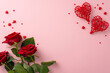 Create romantic mood with St. Valentine's Day elements: top view rattan hearts, red roses, sugar sprinkles on pastel pink, a canvas for your text or advertisement