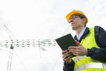 Poster - Engineer with digital tablet on a background of power line tower.