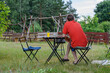 Samotny mężczyzna siedzi sam przy stole w ogrodzie i myśli 