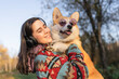 © Westend61 - Happy woman carrying Pembroke welsh corgi wearing sunglasses in park