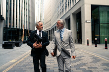 Senior Businessmen Walking And Talking With Each Other