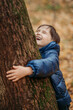 © Westend61 - Happy boy hugging tree at autumn park